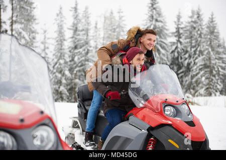 Young men riding snowmobile in winter Stock Photo