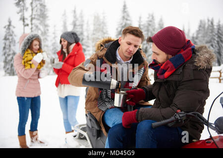 Friends having coffee outdoors in winter Stock Photo