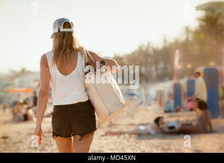Woman walking along  beach, rear view, Sitges, Catalonia, Spain Stock Photo