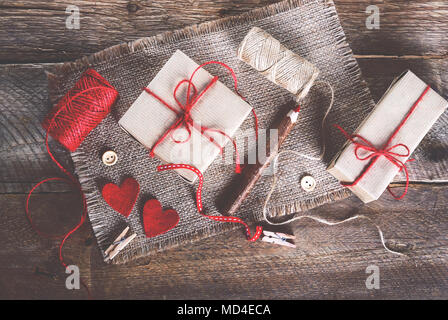 Sewing set: fabrics, threads, pins, buttons, tape and handmade hearts on burlap, sackcloth background Toned effects Stock Photo