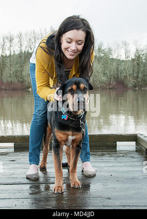 A woman and her dog standing on a dock in Oregon. Stock Photo