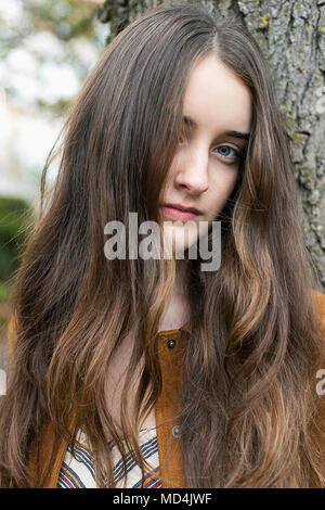 A teenaged girl (13 years old) with long hair, looking at the camera. Stock Photo