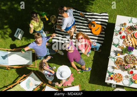 Happy young people relax and play badminton at a barbeque in the garden Stock Photo