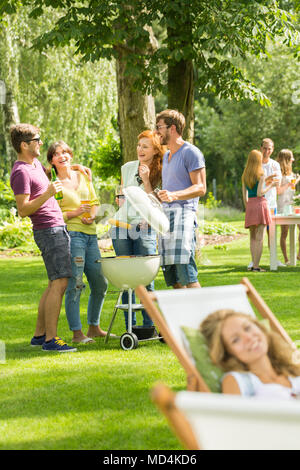 Man have fun with friends while having a common outdoor barbeque on a vacation Stock Photo