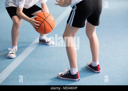 Cropped photo of pupils playing basketball in the gym Stock Photo