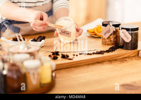 Close-up of person mixing coconut mass during production of natural cosmetics Stock Photo