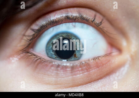 Close-Up Of Beautiful Blue Woman With Crazy Eye Staring At Camera Depicting Insanity Stock Photo