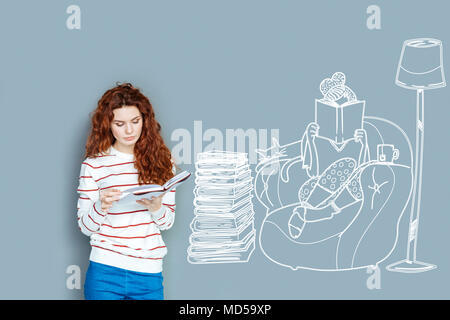Calm student having a pleasant evening while reading at home Stock Photo