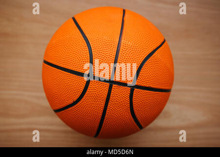 Basketball ball laying on hardwood court floor, top view Stock Photo