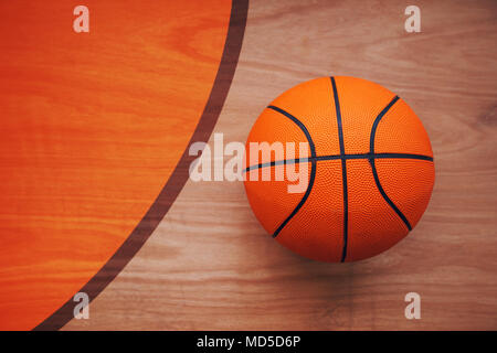 Basketball ball laying on hardwood court floor, top view Stock Photo