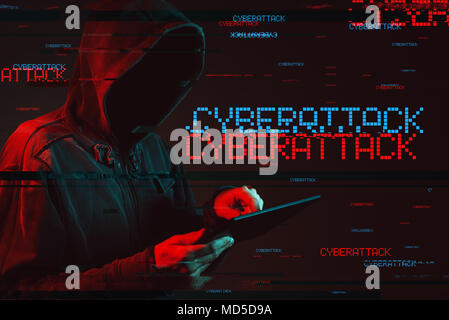 Cyberattack concept with faceless hooded male person using tablet computer, low key red and blue lit image and digital glitch effect Stock Photo