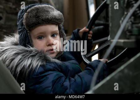 A Polish toddler sits in the driver seat of a U.S. Army Humvee, with help from his father and Soldiers from 2nd Battalion, 70th Armored Regiment, 2nd Armored Brigade Combat Team, 1st Infantry Division, Fort Riley, Kansas, during the 74th anniversary of 'The Great Escape' in Zagan, Poland, March 24, 2018. (U.S. Army photo by Spc. Dustin D. Biven / 22nd Mobile Public Affairs Detachment) Stock Photo