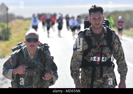 An American and a German participant in the 2018 Bataan Memorial Death March focus on completing a portion of the 26.2-mile course while enduring the heat and elevation at White Sands Missile Range, N.M., March 25, 2018.  The 2018 Bataan Memorial Death March honors those who defended the Philippines during the Japanese invasion in World War II and features the attendance of seven survivors of the Bataan Death March. .  (U.S. Army photo by Pvt. Matthew J. Marcellus) Stock Photo