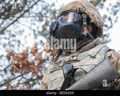 Spc. Antonio Williams, a dental specialist assigned to 810th Dental Company, 424th Medical Battalion, 338th Medical Brigade, 3rd Medical Command (Deployment Support), wearsprotective mask while on patrol for the Combat Support Training Excercise 18-03, at Fort McCoy, Wisconsin, March 20, 2018. Army Reserve Soldiers conduct this exercise annually to increase combat readiness and decrease the amount of preparation time to deploy. (U.S. Army photo by Sgt. Chad Guthrie) Stock Photo