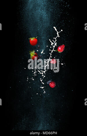 Strawberries and milk on a black background. Stop the moment in zero gravity. A cocktail of fresh berries Stock Photo