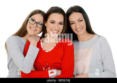 Three beautiful happy girls on sleepover in their pajamas. Friendship, people and pajama party concept - happy friends or teenage girls having fun Stock Photo