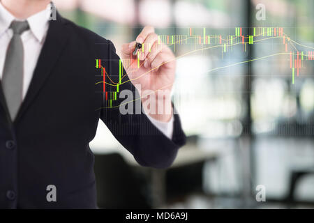 Business person touching finance stock charts and diagrams with pen analyzing data. Stock Photo