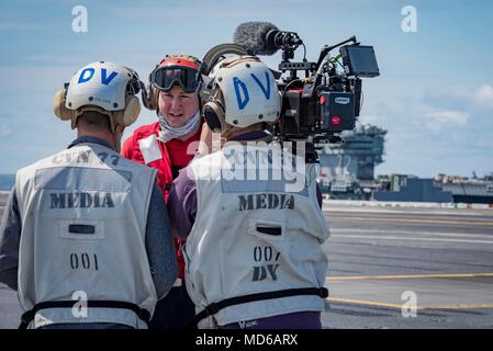 180327-N-SO730-0349 ATLANTIC OCEAN (March 27, 2018) Aviation Ordnanceman 2nd Class Zachary Lott, from Madison, Florida, gives an interview to civilian media about his job in the Navy and life aboard the aircraft carrier USS George H.W. Bush (CVN 77). The ship is underway conducting sustainment exercises to maintain carrier readiness. (U.S. Navy photo by Mass Communication Specialist 3rd Class Joe Boggio) Stock Photo