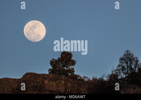 La Luna llena de febrero, conocida como Luna de Nieve, pudo verse mientras el satélite ingresaba en la zona de penumbra de la Tierra, en lo que se conoce como un eclipse penumbral. Aqui se observa su salida en el horizonte de los cerrros cercanos a Creel, Chihuahua, Mexico donde habita la comunidad indigena raramuri The full moon of February, known as Snow Moon, could be seen as the satellite entered the penumbra zone of the Earth, in what is known as a penumbral eclipse. Here it is observed its exit in the horizon of the hills near Creel, Chihuahua, Mexico where inhabits the indigenous commun Stock Photo