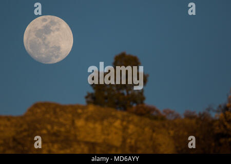 La Luna llena de febrero, conocida como Luna de Nieve, pudo verse mientras el satélite ingresaba en la zona de penumbra de la Tierra, en lo que se conoce como un eclipse penumbral. Aqui se observa su salida en el horizonte de los cerrros cercanos a Creel, Chihuahua, Mexico donde habita la comunidad indigena raramuri The full moon of February, known as Snow Moon, could be seen as the satellite entered the penumbra zone of the Earth, in what is known as a penumbral eclipse. Here it is observed its exit in the horizon of the hills near Creel, Chihuahua, Mexico where inhabits the indigenous commun Stock Photo