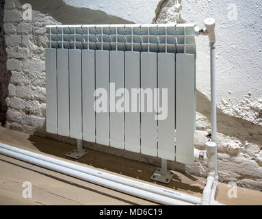 Modern radiator on the background with a partially plastered wall Stock Photo