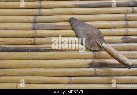 steel trowel on bamboo Stock Photo