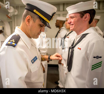 180320-N-NG136-0066 NORFOLK, Va. (March 20, 2018) Chief Warrant Officer 2 Gabrielle Arroyo, left, inspects Airman Josh Weaver's service dress white uniform aboard the aircraft carrier USS George H.W. Bush (CVN 77). The ship is in port in Norfolk, Virginia, conducting sustainment exercises to maintain carrier readiness. (U.S. Navy photo by Mass Communication Specialist 3rd Class Zachary P. Wickline) Stock Photo