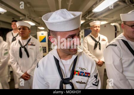 180320-N-NG136-0088 NORFOLK, Va. (March 20, 2018) Aviation Ordnanceman 3rd Class Julio Pino laughs after a service dress white uniform inspection aboard the aircraft carrier USS George H.W. Bush (CVN 77). The ship is in port in Norfolk, Virginia, conducting sustainment exercises to maintain carrier readiness. (U.S. Navy photo by Mass Communication Specialist 3rd Class Zachary P. Wickline) Stock Photo