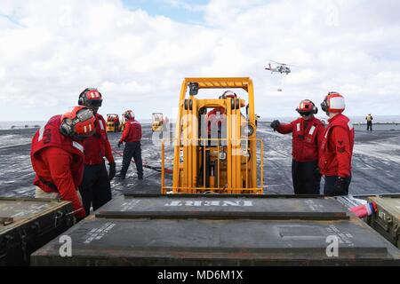 180326-N-FQ836-0132 ATLANTIC OCEAN (March 26, 2018) Sailors transport ordnance on the flight deck of the Nimitz-class aircraft carrier USS Abraham Lincoln (CVN 72) during an underway replenishment and ammunition onload. (U.S. Navy photo by Mass Communication Specialist 3rd Class Jeff Sherman/Released) Stock Photo