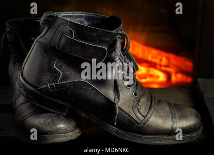 Casual gray leather shoes for men on wooden board with fireplace in the background. Dark mood style. Horizontal image. Stock Photo