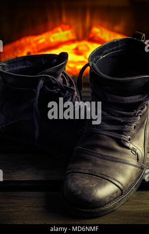 Casual gray leather shoes for men on wooden board with fireplace in the background. Dark mood style. Vertical image. Stock Photo