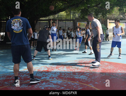 180328-N-FN963-0130 HONG KONG (March 28, 2018) Sailors assigned to the Arleigh Burke-class guided-missile destroyer USS Sterett (DDG 104) play basketball with students from the Yan Chai Hospital Secondary School during a cultural exchange event. Sterett is in Hong Kong to experience the city’s rich culture and history as the guided-missile destroyer continues its deployment with the Wasp Expeditionary Strike Group as a multi-mission asset in the Indo-Pacific region. (U.S. Navy photo by Mass Communication Specialist 2nd Class Richard L.J. Gourley/Released) Stock Photo