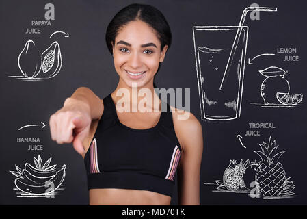 Young nutrition expert pointing in front of herself while talking about juice Stock Photo