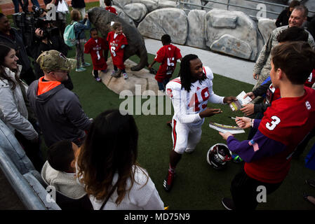 A.J. Thompson, Jr., North Carolina State University defensive back, signs autographs for Seymour Johnson Air Force Base, North Carolina, and Fort Bragg, North Carolina, families following a team practice, March 23, 2018, at NC State University in Raleigh, North Carolina. The families, who currently or are soon expecting to have a member deployed, were invited to the campus to get a full-blown sporting experience to help them cope with their separation. (U.S. Air Force photo by Staff Sgt. Brittain Crolley) Stock Photo