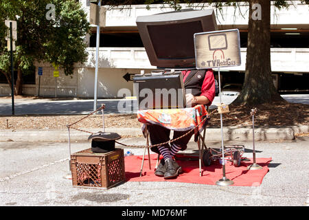 A man with a prop TV on his head, manipulates a circuit board to make the sounds of TV channels changing, on October 4, 2014 in Decatur, GA. Stock Photo