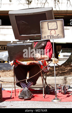 A man with a prop TV on his head, manipulates a circuit board to make the sounds of TV channels changing, on October 4, 2014 in Decatur, GA. Stock Photo