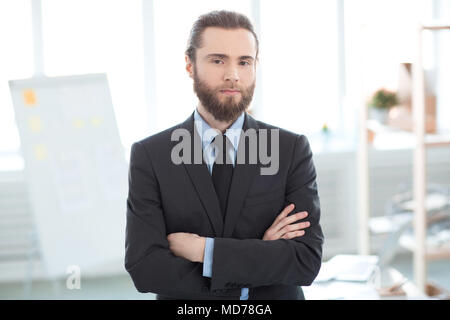 Portrait of bearded businessman standing with arms crossed at office Stock Photo