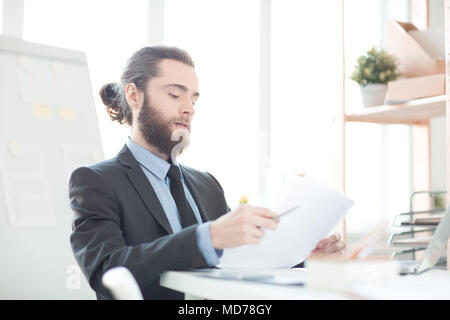 Bearded businessman working with documents at his workplace Stock Photo