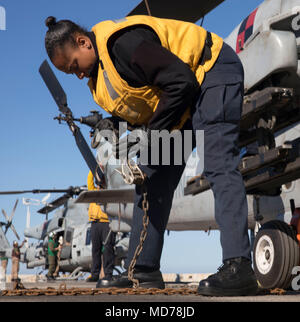 180330-N-GR168-0019 MEDITERRANEAN SEA (March 30, 2018) Aviation Boatswain’s Mate (Fuel) 3rd Class Tameca McKenzie, from Montego Bay, Jamaica, secures an AH-1W Cobra helicopter, attached to Marine Medium Tiltrotor Squadron (VMM) 162 (Reinforced), to the flight deck of the San Antonio-class amphibious transport dock ship USS New York (LPD 21) March 30, 2018. New York, homeported in Mayport, Florida, is conducting naval operations in the U.S. 6th Fleet area of operations. (U.S. Navy photo by Mass Communication Specialist 2nd Class Lyle Wilkie/Released) Stock Photo