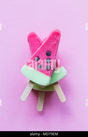 Watermelon shaped summer ice lolly on a pastel pink background Stock Photo