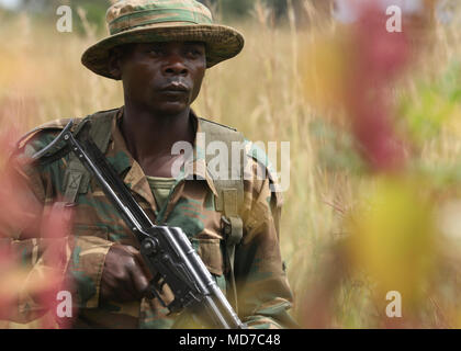 A Zambian soldier maintains security while on a patrol during ZAMBAT IV at the Nanking Peace Mission Training Center, Lusaka, Zambia, March 26, 2018. Training modules included: marksmanship, mounted battle drills, training alongside Indian Army counterparts for battlefield trauma, cordon and search, and convoy operations with British soldiers. Zambian Infantry soldiers rehearsed tactics and real-world scenarios likely to be encountered while serving in support of the United Nations Multidimensional Stabilization mission in the Central African Republic (MINUSCA). (U.S. Army photo by Sgt. Asa Bi Stock Photo