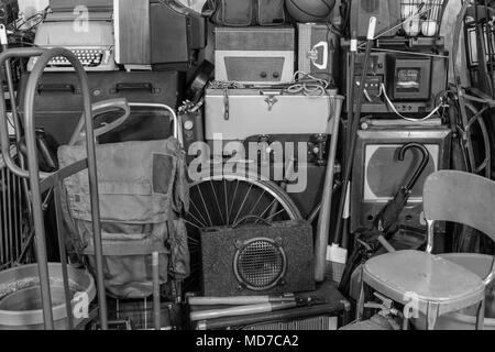 Vintage garage storage area with old tools, gardening, music and sports equipment in black and white. Stock Photo