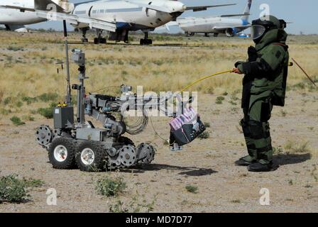 Staff Sgt. Michael Sprouse from San Diego, Calif., an explosive ordnance disposal team leader with the 741st Ordnance Company, 3rd Ord. Battalion., at Fort Bliss, Texas, passes off a suspected exercise improvised explosive device to an ANDROS EOD robot at Pinal Air Park, Ariz. during Raven’s Challenge XII, March 19-23. The Raven’s Challenge Exercise is an annual, interagency, counter IED exercise that incorporates scenarios focused on interoperability capabilities between public safety bomb squads (PSBSs) and military EOD units in operational environments. Stock Photo