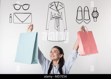Excited student putting her hands up while doing shopping Stock Photo