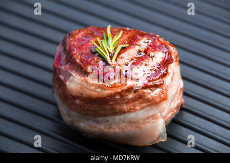 Cooked fillet mignon steak with bacon and rosemary on grill pan. Tasty and healthy food background. Stock Photo