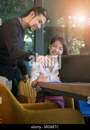 couples of asian younger freelance working with happiness emotion at home office Stock Photo