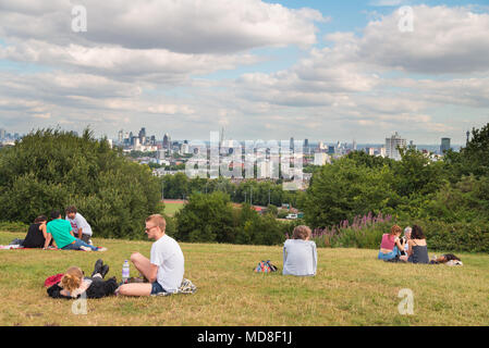 People relax and enjoy the panoramic view of the London skyline on a summer afternoon on Parliament Hill on Hampstead Heath in north London Stock Photo