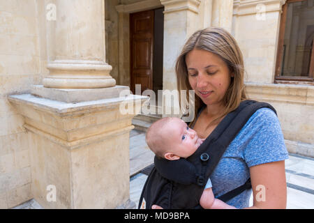 Mother with cute little baby boy in carrier, Heraklion, Greece Stock Photo