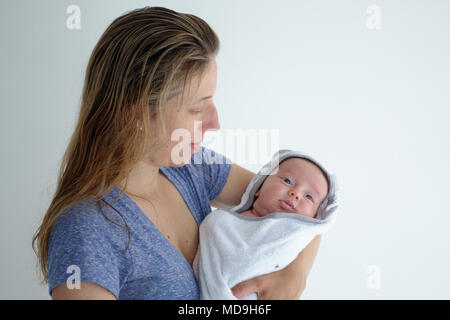 Mother holding her cute little baby wrapped in towel Stock Photo