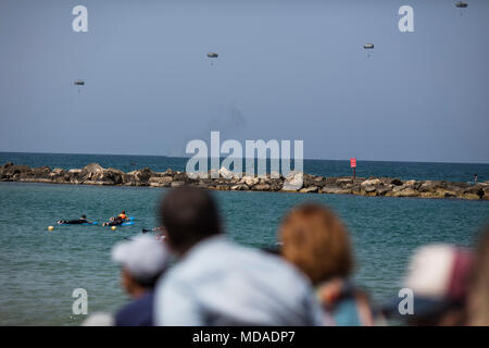 Tel Aviv, Israel. 19th Apr, 2018. People watch parachuting show during the celebrations marking the 70th anniversary of Israel's independence, in Tel Aviv, Israel, 19 April 2018. The day marks when David Ben-Gurion, the Executive Head of the World Zionist Organization, declared independence on the ashes of the Holocaust and the end of the British Mandate over Palestine in 1948. Credit: Ilia Yefimovich/dpa/Alamy Live News Stock Photo